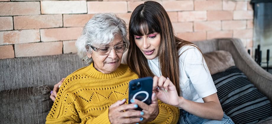 Young adult and older woman looking at phone.