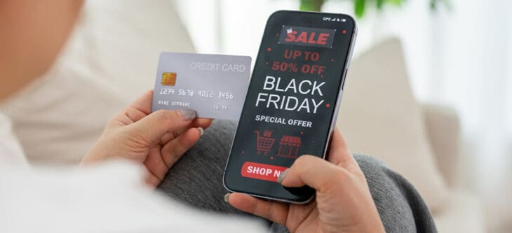Person holding smartphone and credit card shopping online