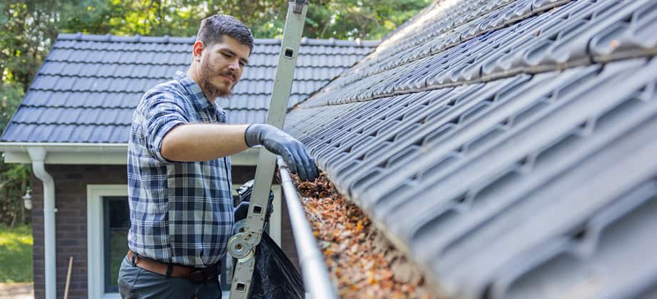 Man cleaning gutters